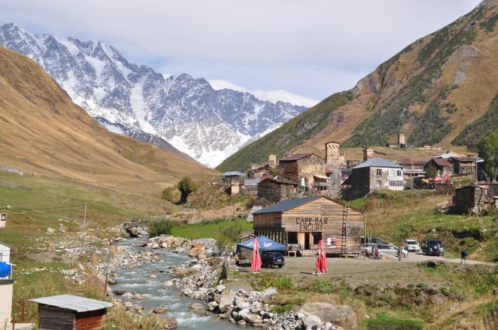 Remote mountain village with stone towers in a green valley in Ushguli, one of the hidden gems to visit